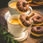 Two cups of Caffe Americano with small chocolate donuts